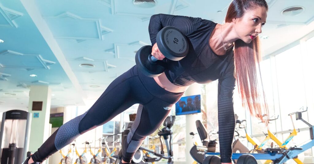 Woman performing a plank row with dumbbells in a bright Dubai gym.